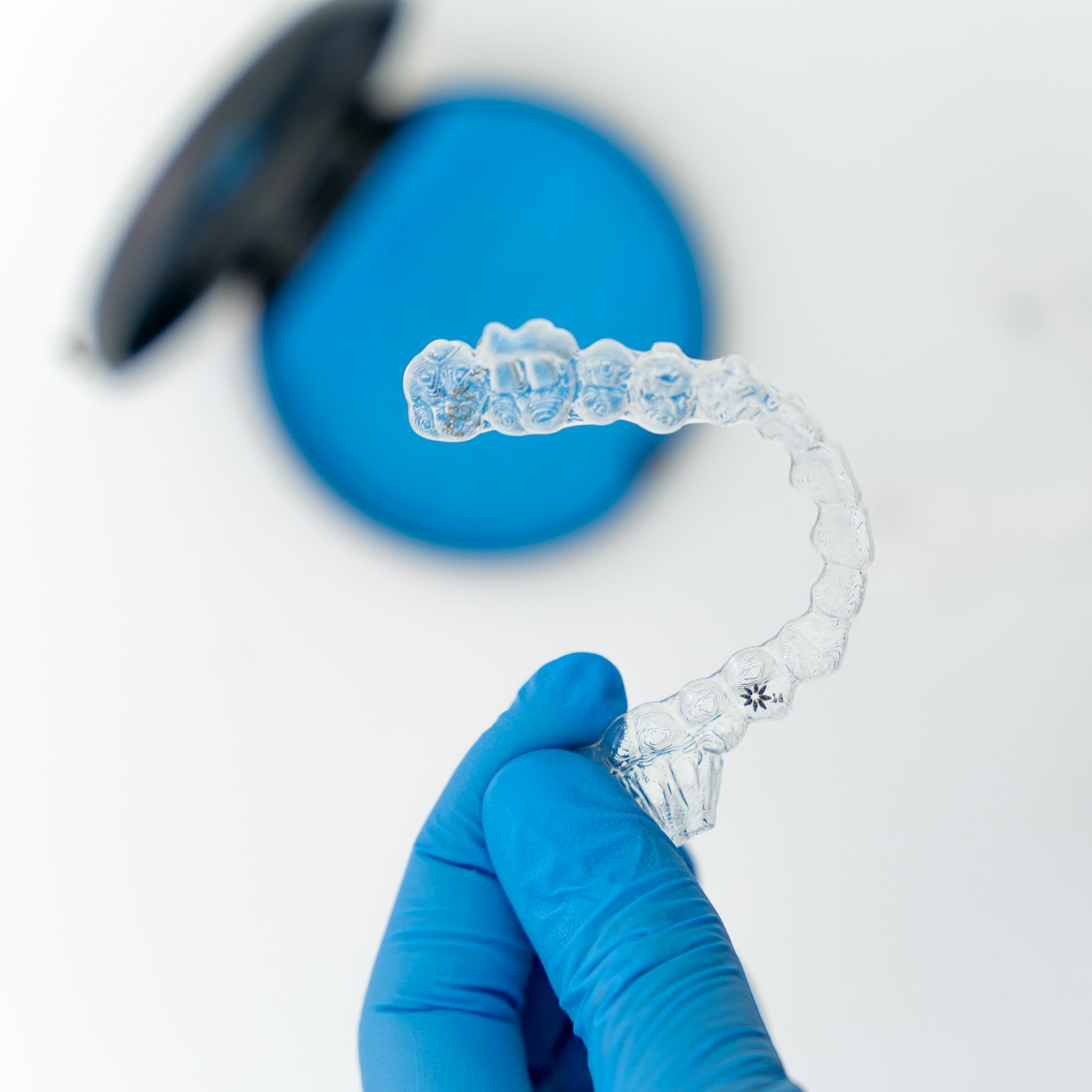 Clear retainer held in a gloved hand
